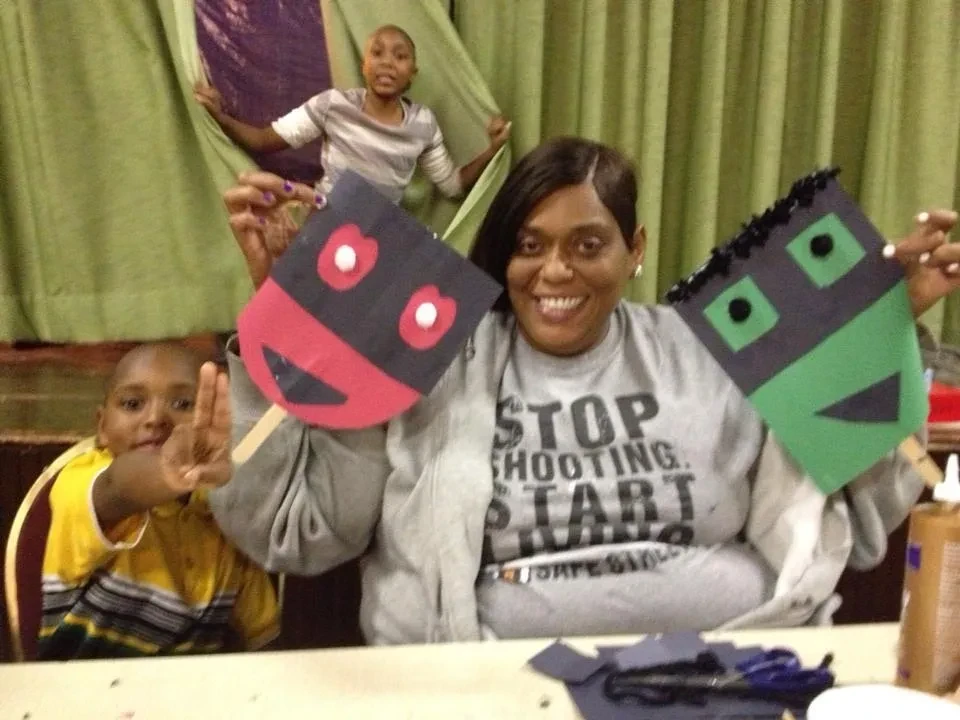 Community member and children showing handmade craft masks