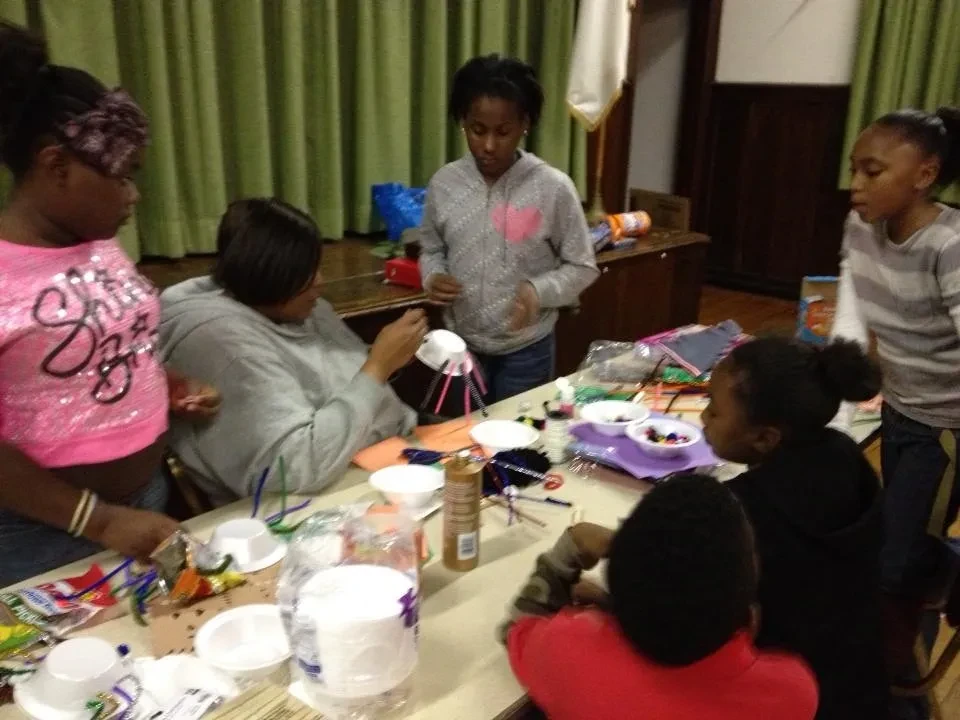 Children engaged in arts and crafts activity at a table